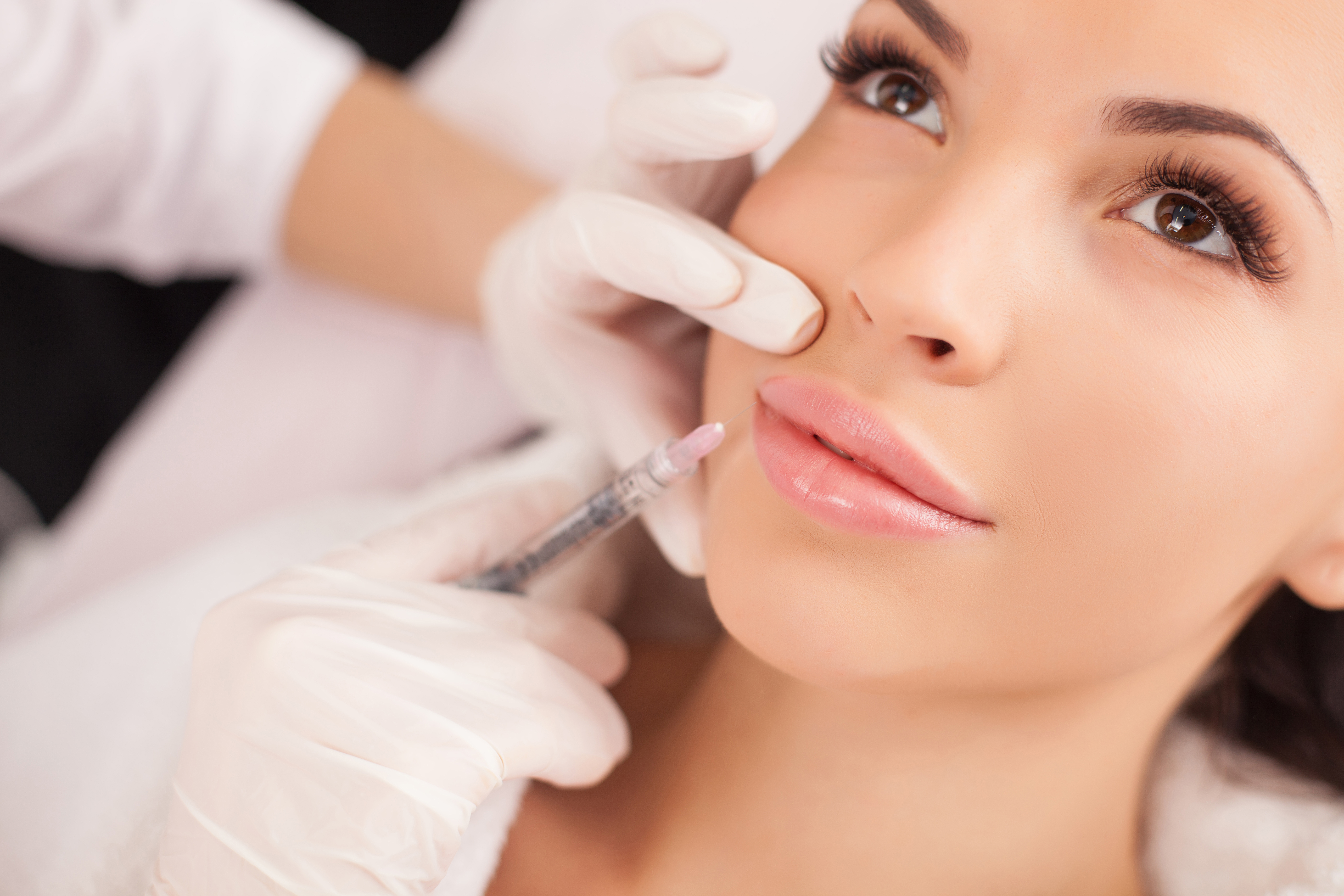 Woman receiving lip filler injections